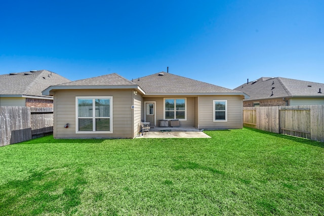 rear view of property with a yard, roof with shingles, a fenced backyard, and a patio area