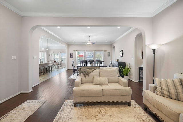 living room with baseboards, arched walkways, and wood-type flooring