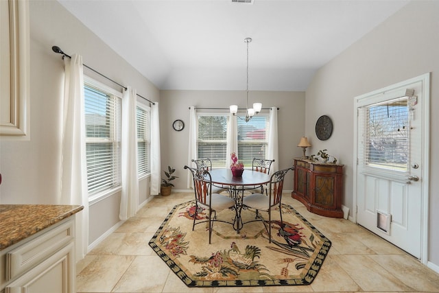 dining room with a wealth of natural light, baseboards, lofted ceiling, and a chandelier