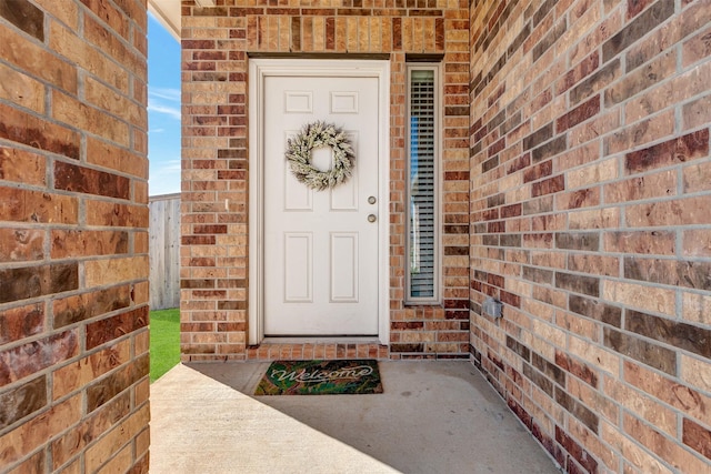 view of exterior entry featuring brick siding