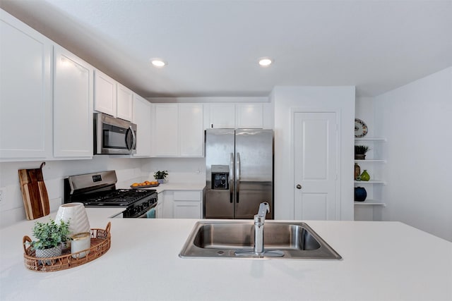 kitchen with light countertops, recessed lighting, white cabinets, stainless steel appliances, and a sink