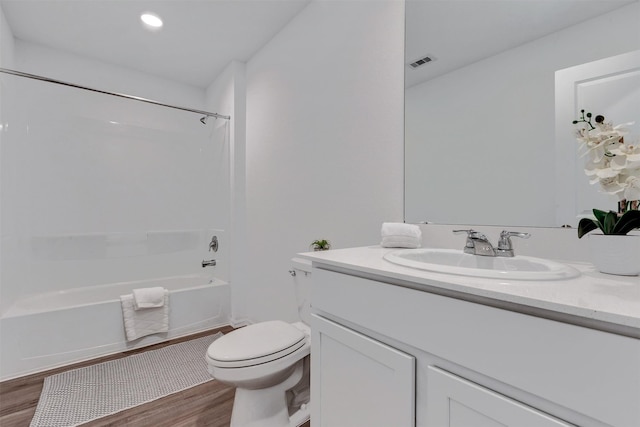 full bathroom with vanity, wood finished floors, visible vents, toilet, and shower / bathtub combination