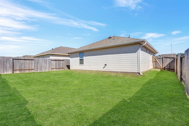 back of property featuring a lawn and a fenced backyard