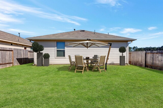 rear view of house with a lawn and a fenced backyard