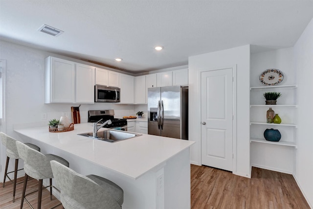 kitchen with visible vents, light countertops, appliances with stainless steel finishes, white cabinetry, and a sink