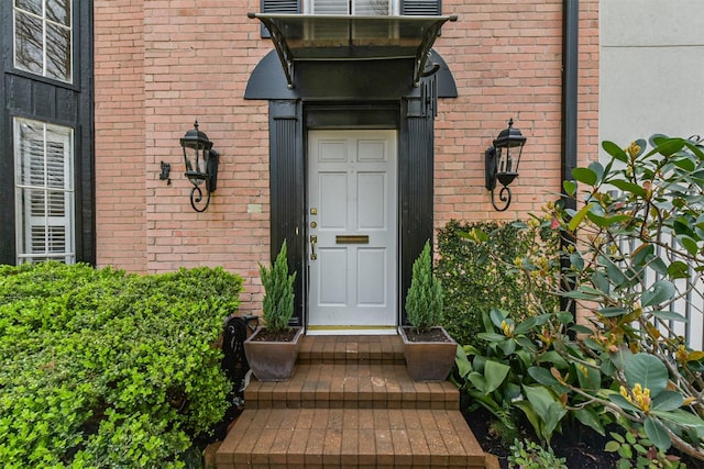 entrance to property featuring brick siding