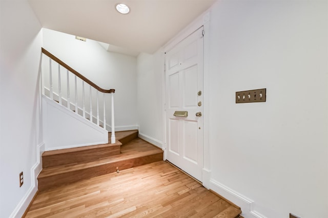 entrance foyer featuring stairway, baseboards, and light wood finished floors