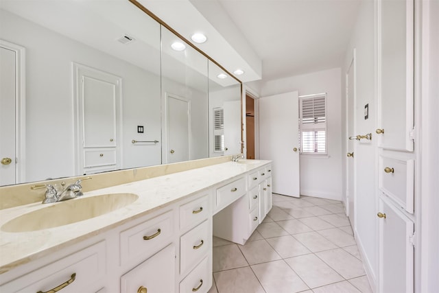 full bathroom with a sink, visible vents, double vanity, and tile patterned floors