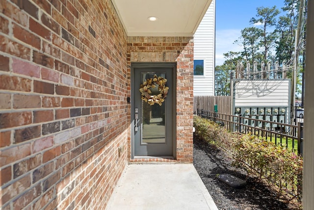 entrance to property with brick siding and fence