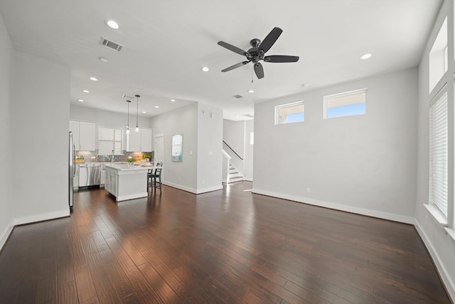 unfurnished living room with recessed lighting, visible vents, dark wood-style flooring, and baseboards