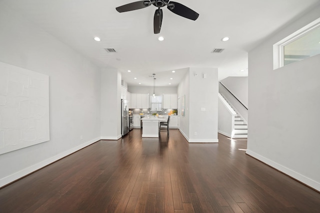 unfurnished living room featuring recessed lighting, baseboards, and dark wood-style flooring