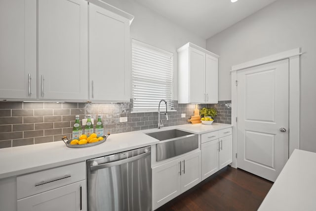 kitchen with backsplash, dishwasher, light countertops, white cabinets, and a sink