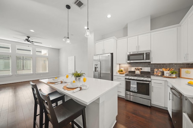 kitchen featuring tasteful backsplash, visible vents, light countertops, dark wood-style floors, and stainless steel appliances