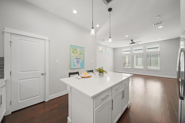 kitchen featuring visible vents, dark wood finished floors, recessed lighting, light countertops, and a center island