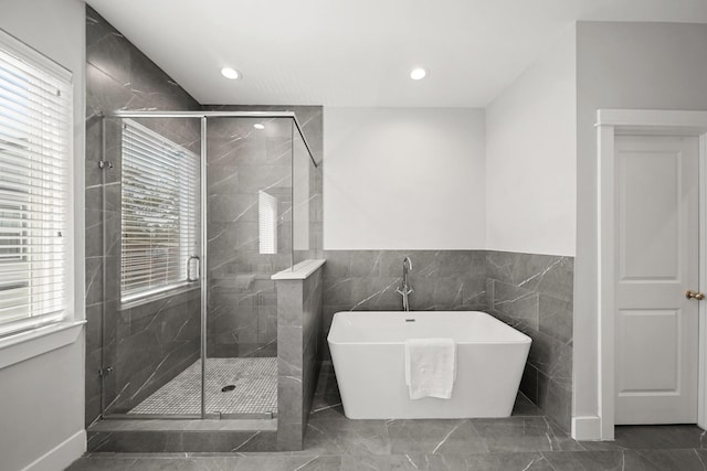 bathroom with a wealth of natural light, recessed lighting, a shower stall, and a freestanding tub