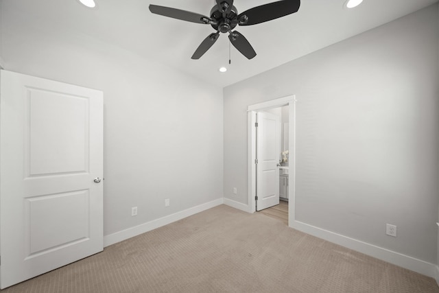 unfurnished bedroom with recessed lighting, baseboards, light carpet, and ensuite bath