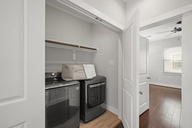 laundry room with laundry area, wood finished floors, baseboards, and washer and clothes dryer