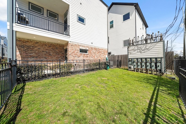 view of yard with a balcony and a fenced backyard