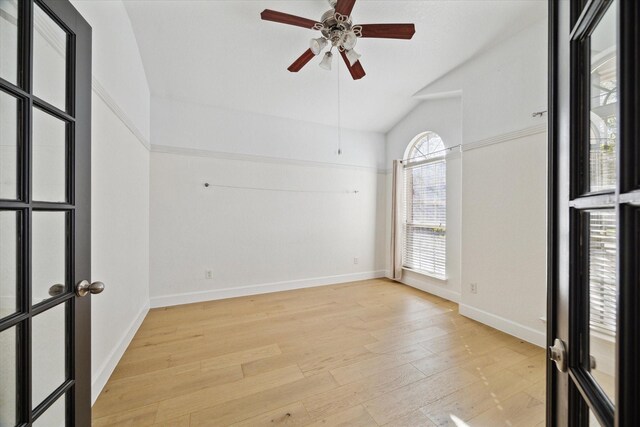 unfurnished room featuring vaulted ceiling, baseboards, light wood finished floors, and ceiling fan