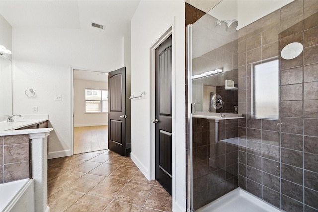 bathroom with tile patterned flooring, visible vents, tiled shower, and vanity