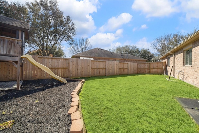 view of yard with a fenced backyard and a playground