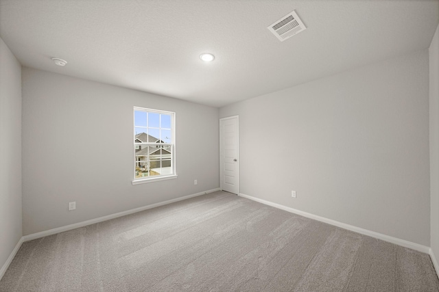 empty room with visible vents, baseboards, and carpet floors