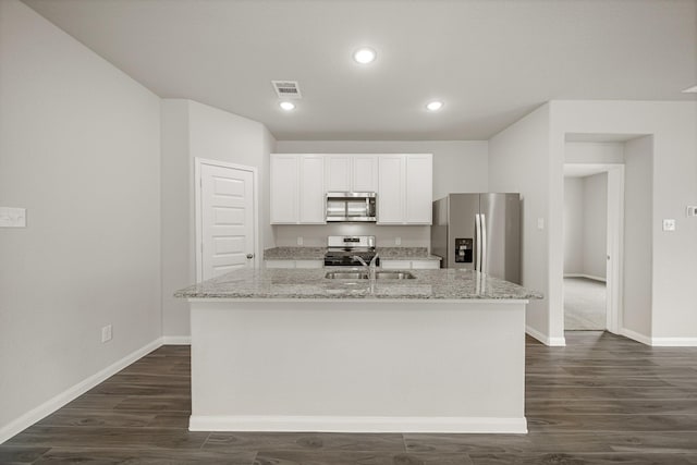 kitchen with visible vents, a center island with sink, a sink, appliances with stainless steel finishes, and white cabinets