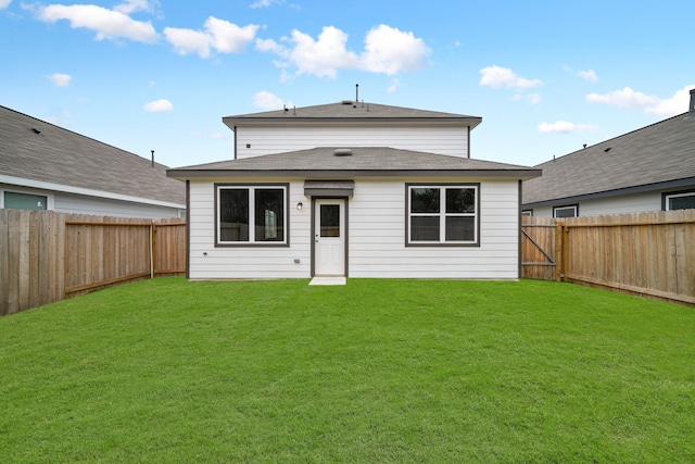 back of property featuring a yard and a fenced backyard