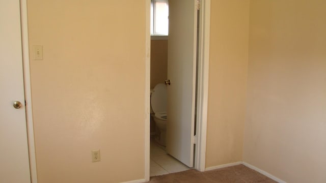 unfurnished bedroom featuring light carpet and baseboards