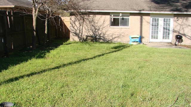 view of yard with french doors and a fenced backyard