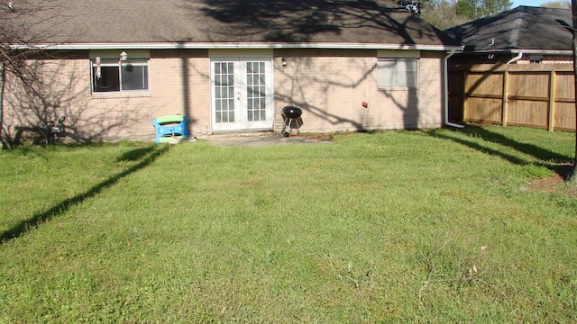 view of yard featuring french doors and fence