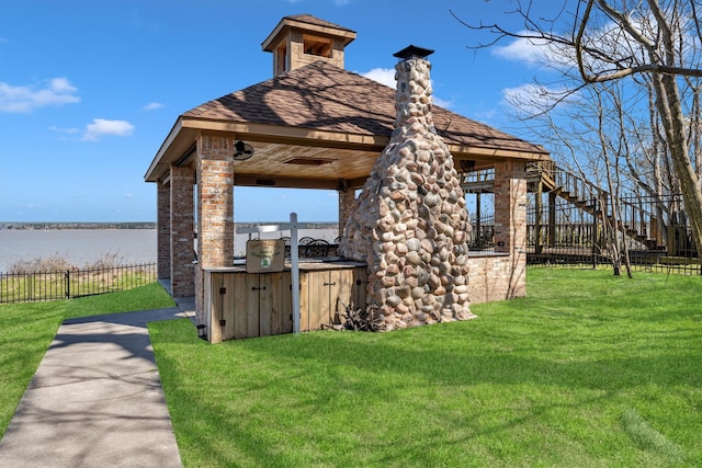 exterior space featuring fence and a water view