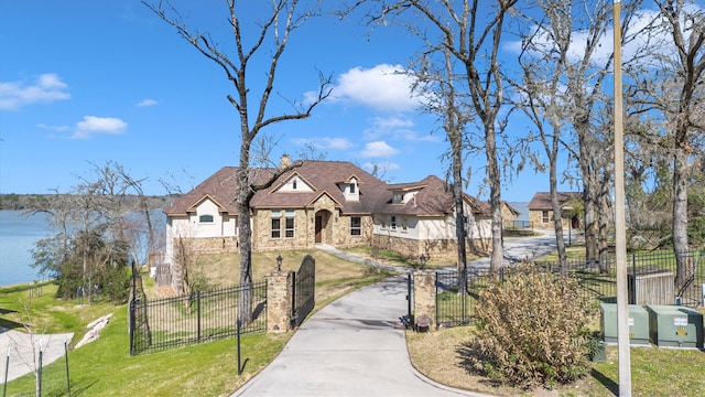 view of front facade with a front yard, stone siding, a fenced front yard, and stucco siding