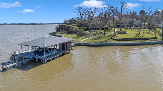 dock area featuring boat lift, a yard, and a water view