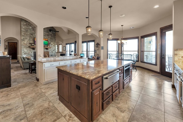 kitchen featuring light stone counters, a healthy amount of sunlight, and a warming drawer