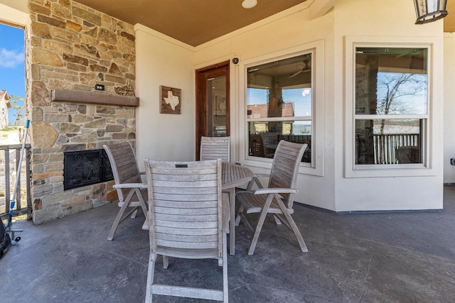 view of patio / terrace with outdoor dining area and an outdoor stone fireplace