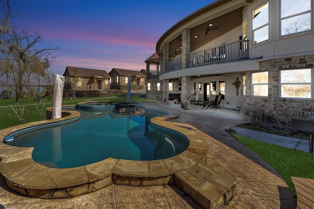 view of swimming pool with a patio area, a pool with connected hot tub, and ceiling fan