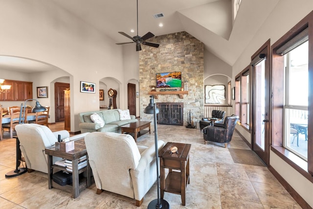 living area with visible vents, plenty of natural light, arched walkways, and a fireplace