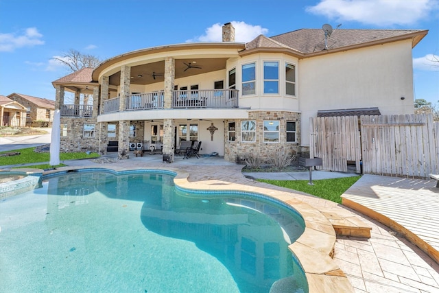 back of house with ceiling fan, fence, stucco siding, a balcony, and a patio area