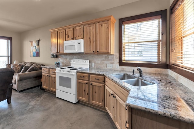 kitchen with a sink, tasteful backsplash, open floor plan, white appliances, and light stone countertops