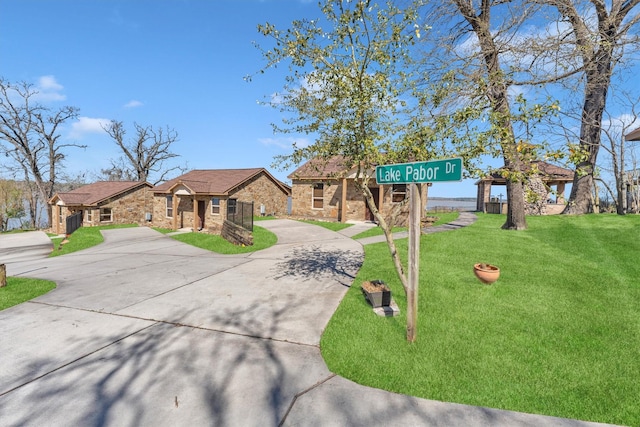 view of front of property with stone siding, driveway, and a front yard