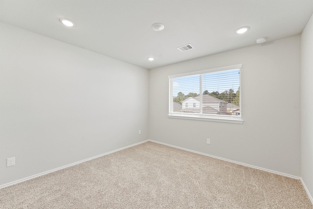 carpeted empty room featuring recessed lighting, visible vents, and baseboards