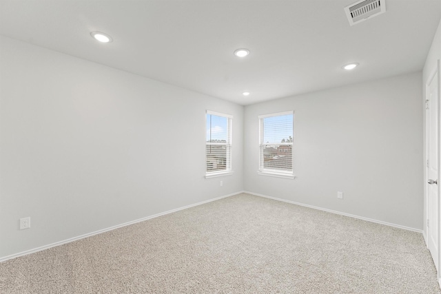 carpeted empty room featuring recessed lighting, visible vents, and baseboards