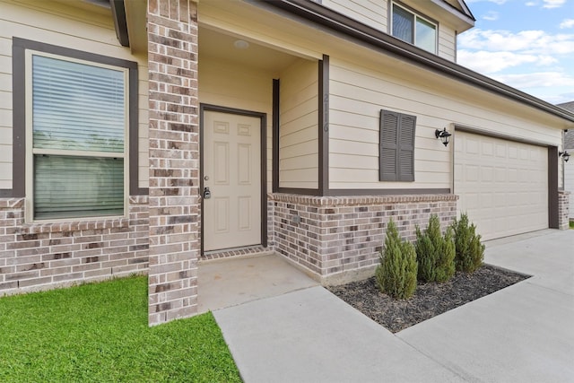 doorway to property featuring concrete driveway and brick siding