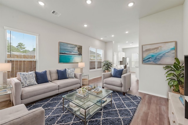 living room featuring recessed lighting, wood finished floors, visible vents, and baseboards