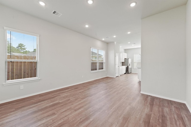 unfurnished living room with recessed lighting, light wood-type flooring, baseboards, and visible vents