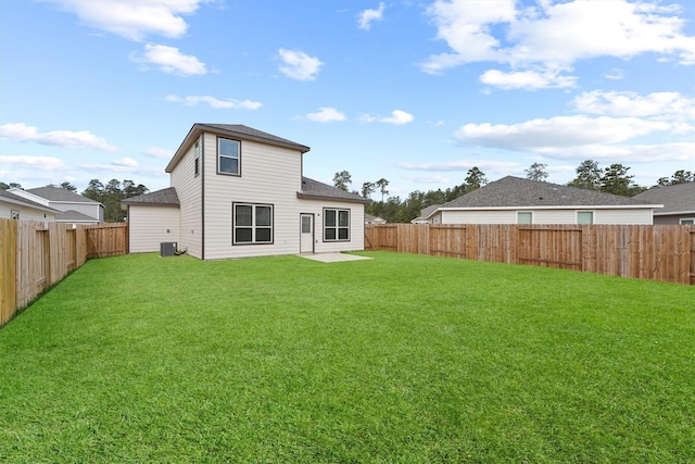 rear view of property featuring a lawn, central AC, and a fenced backyard