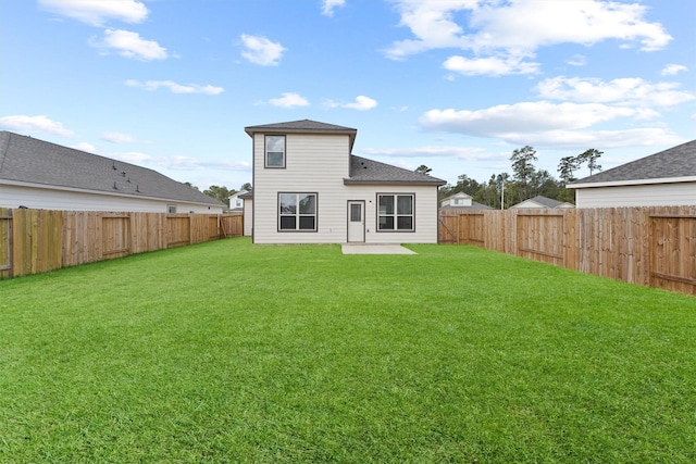 back of property with a lawn and a fenced backyard