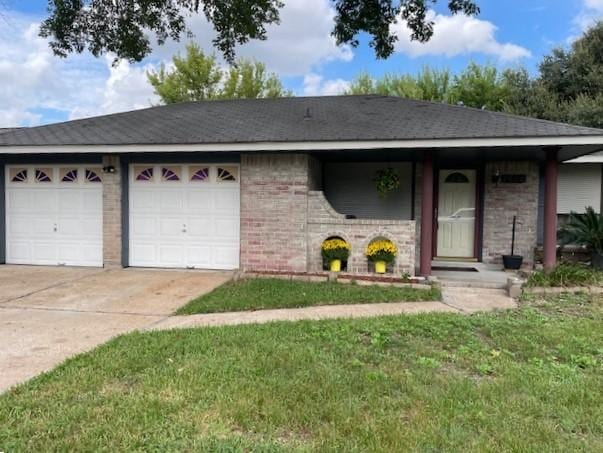 ranch-style home with brick siding, an attached garage, concrete driveway, and a front lawn