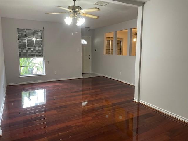 unfurnished room with wood finished floors, visible vents, and baseboards